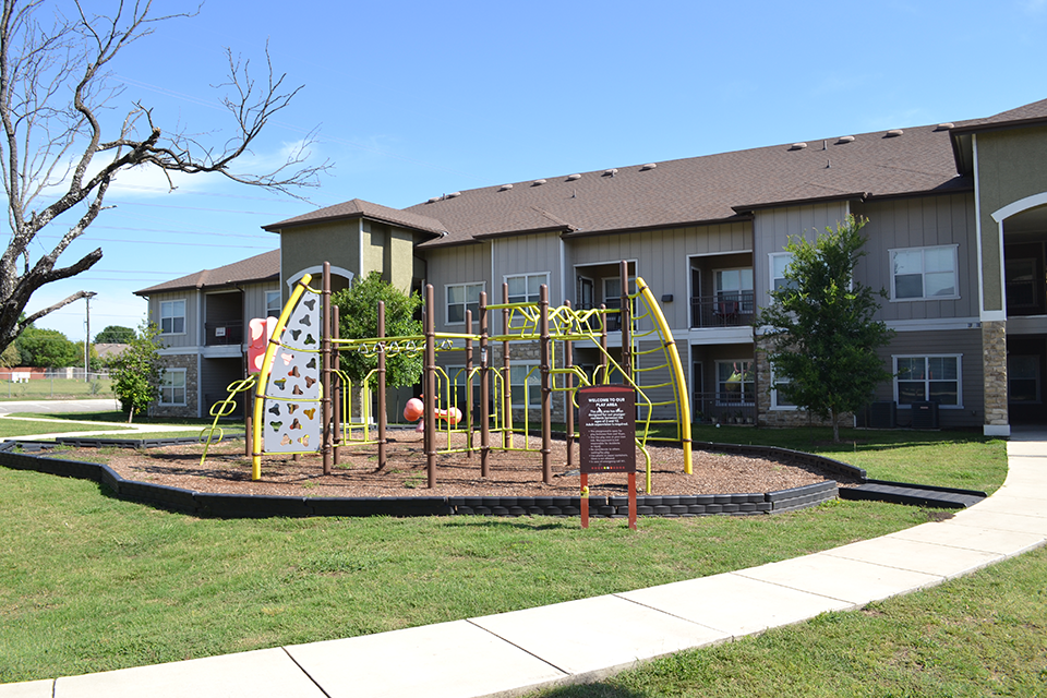 an outdoor playground in front of an apartment building