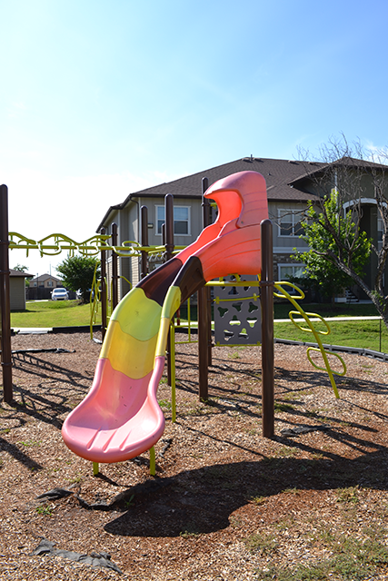 a slide on a playground in front of a house