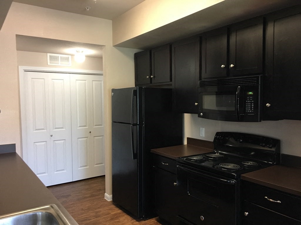 a kitchen with black appliances and black cabinets