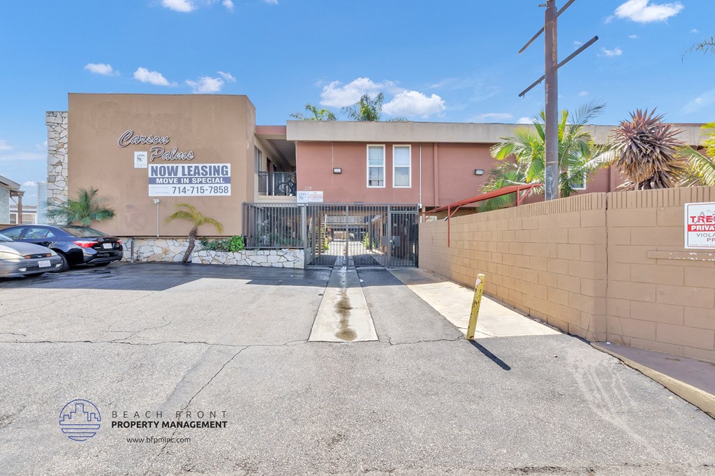 an empty parking lot in front of a building with a gate
