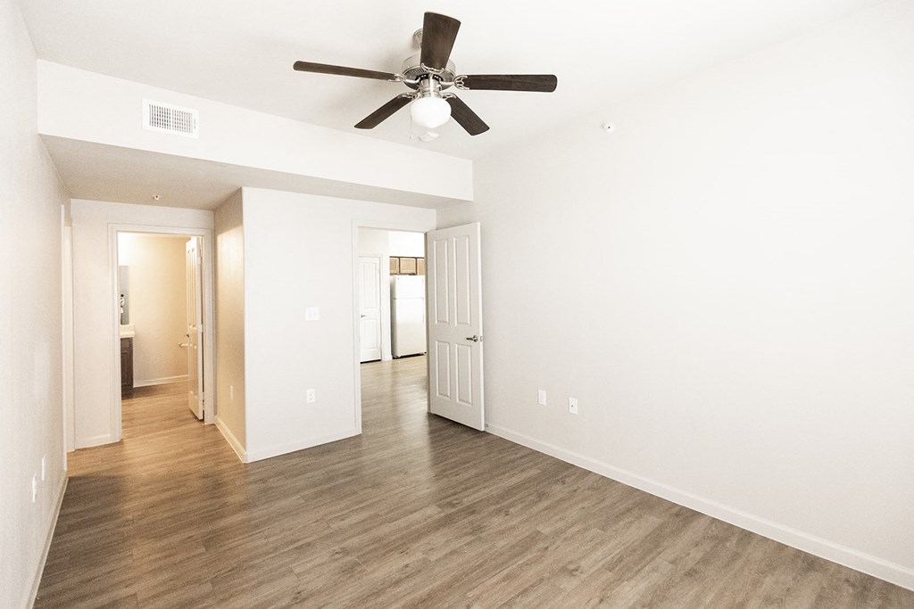 a living room with white walls and a ceiling fan