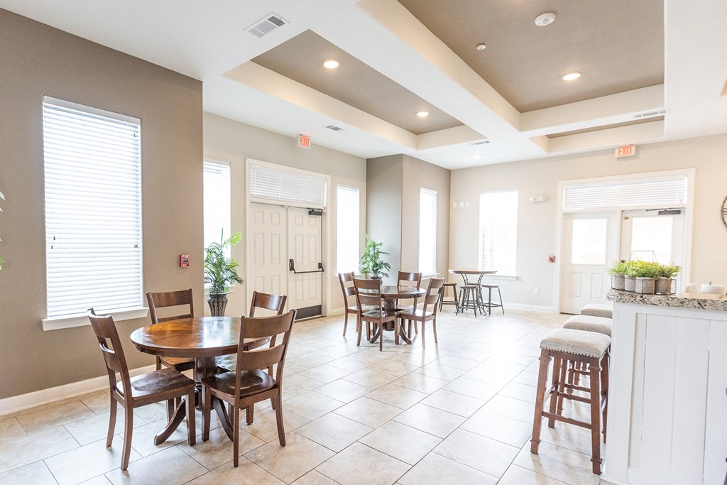 a dining room with tables and chairs and a kitchen