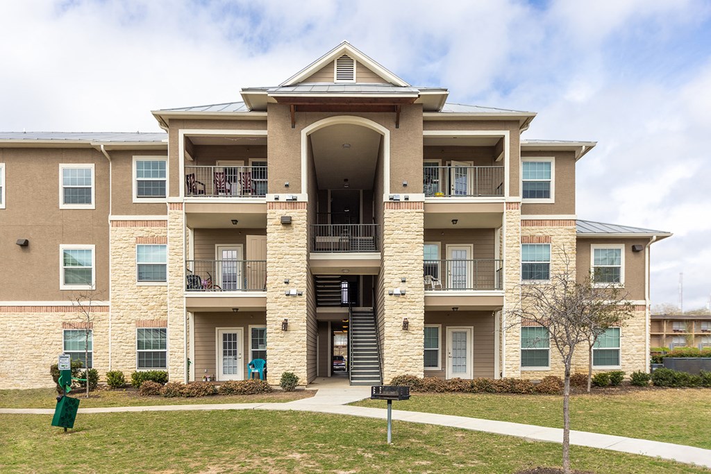 an apartment building with a sidewalk in front of it
