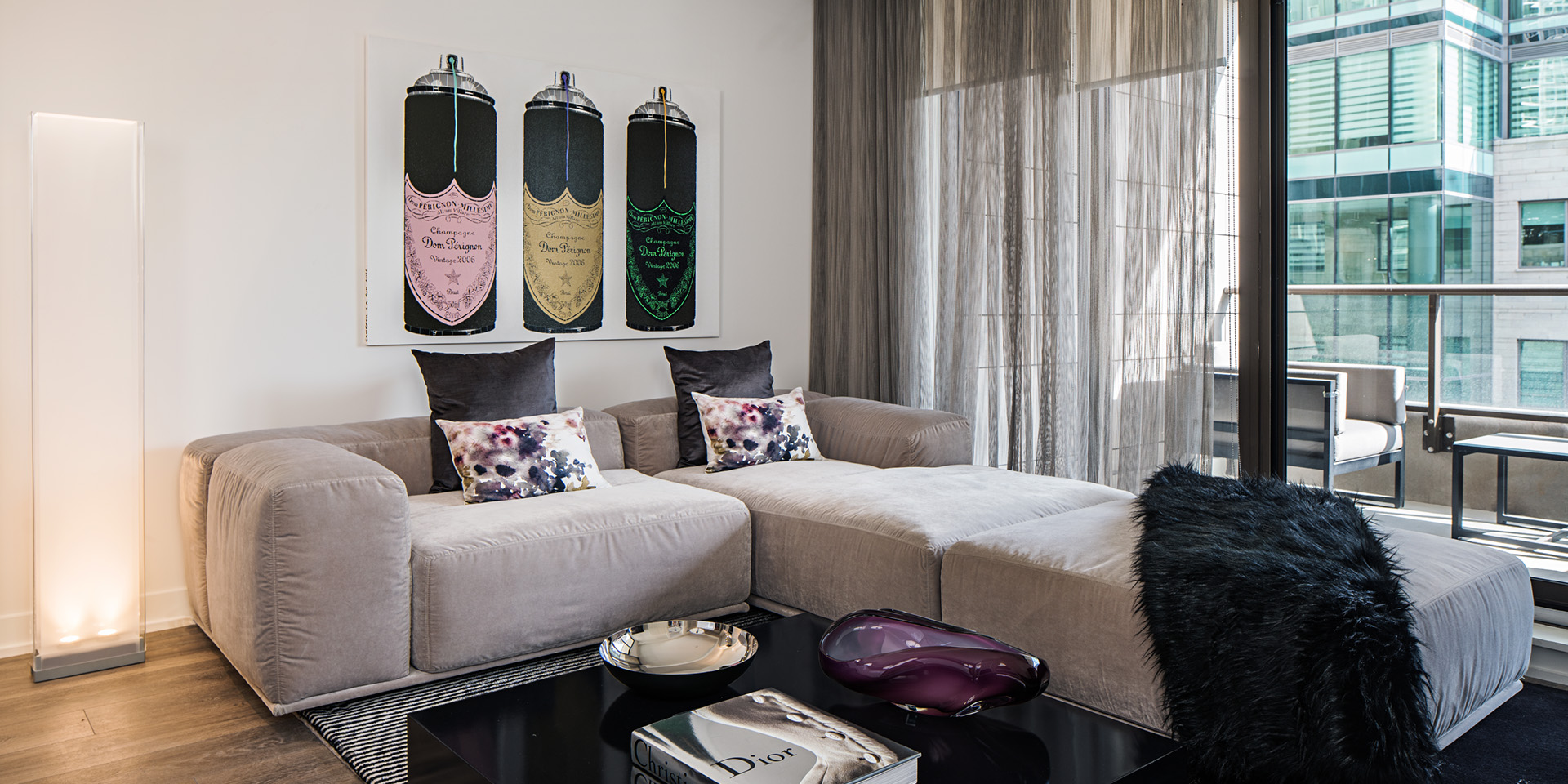 A living room with a couch, a bed, and a table.