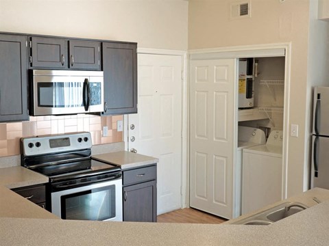 A kitchen with black cabinets and a stove top oven.