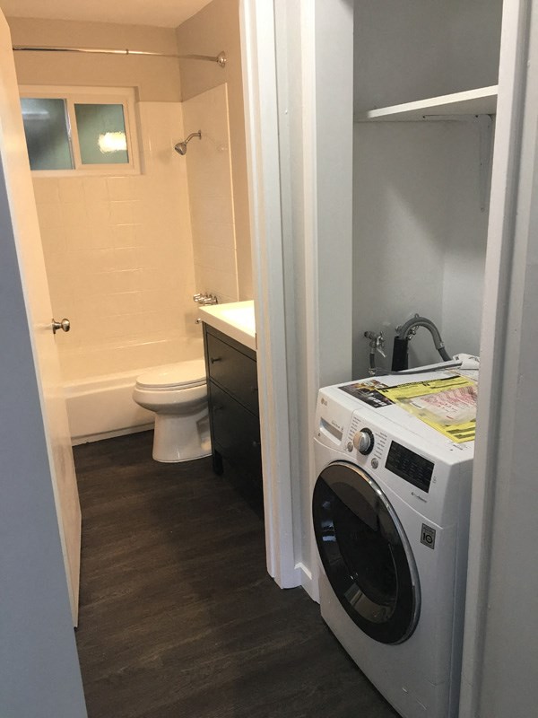 a small bathroom with a washing machine and a toilet