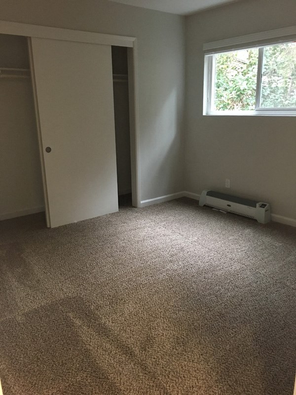an empty room with a carpeted floor and a window