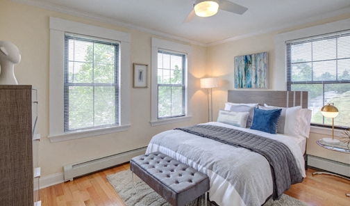 A bedroom with a large bed and a ceiling fan.