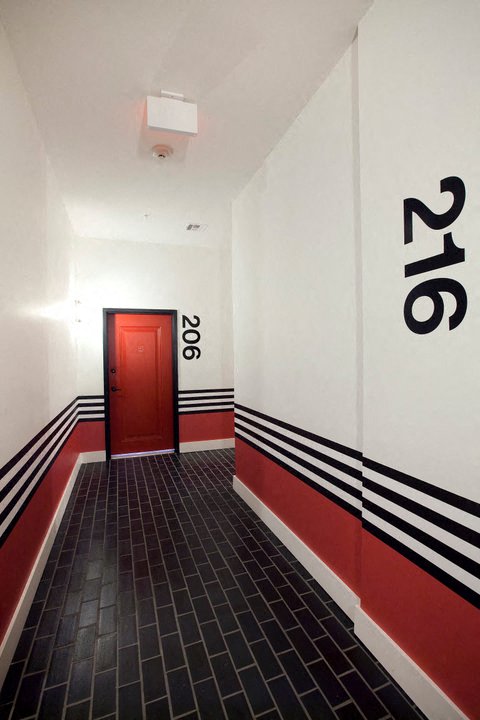 Hallways with different unit entrances - black tiles and red and black designs on walls