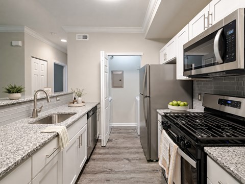 A modern kitchen with granite countertops and stainless steel appliances.