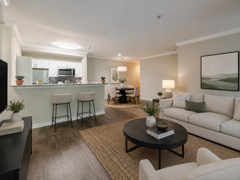 A modern living room with a bar area and a kitchen in the background.