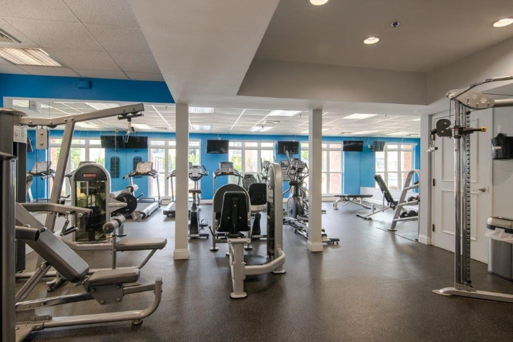 a gym with weights and cardio equipment in a building