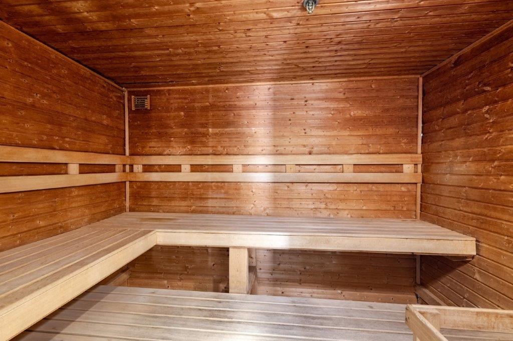 the inside of an empty wooden sauna with wooden benches