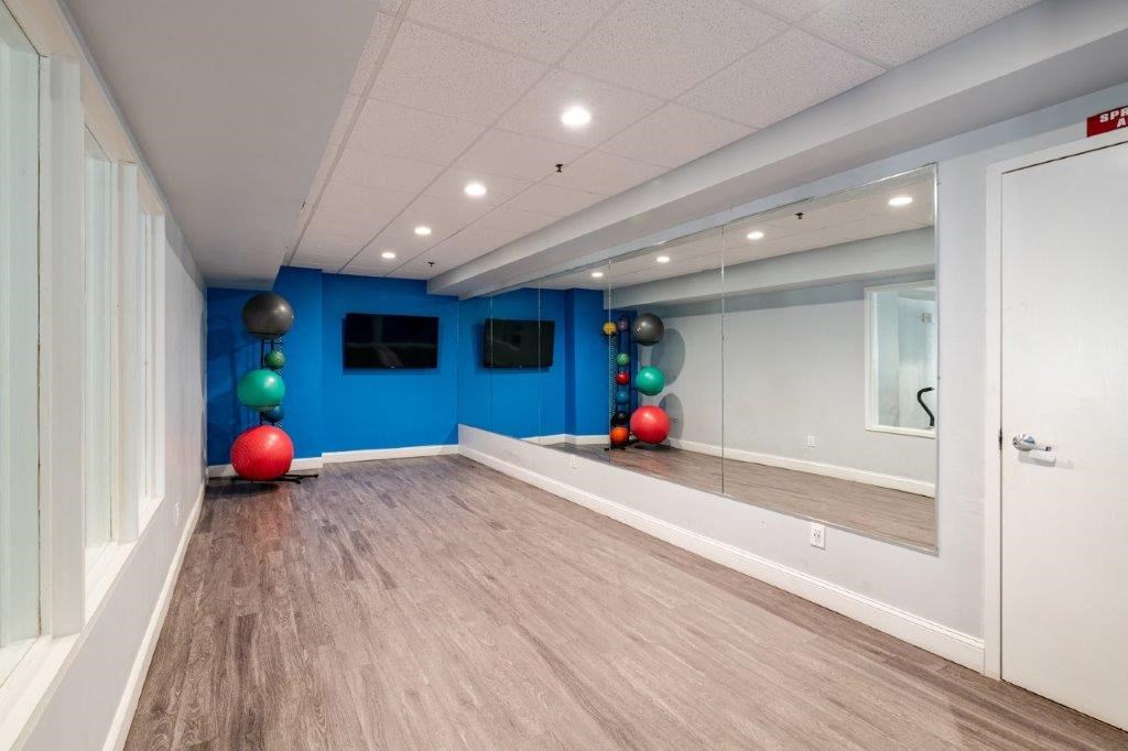 a yoga room with a mirrored wall and a red and blue ball