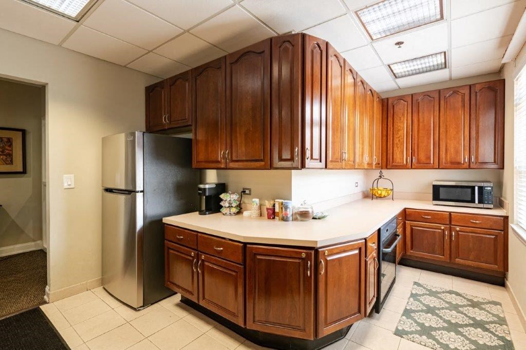 a kitchen with wooden cabinets and a stainless steel refrigerator