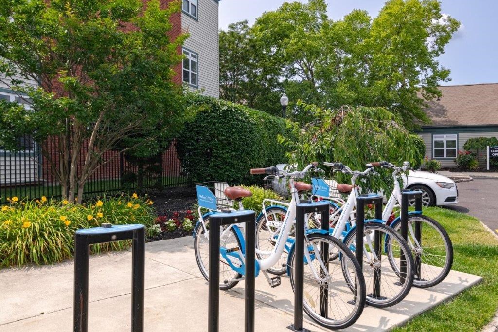 a group of bikes parked on a sidewalk in front of a house