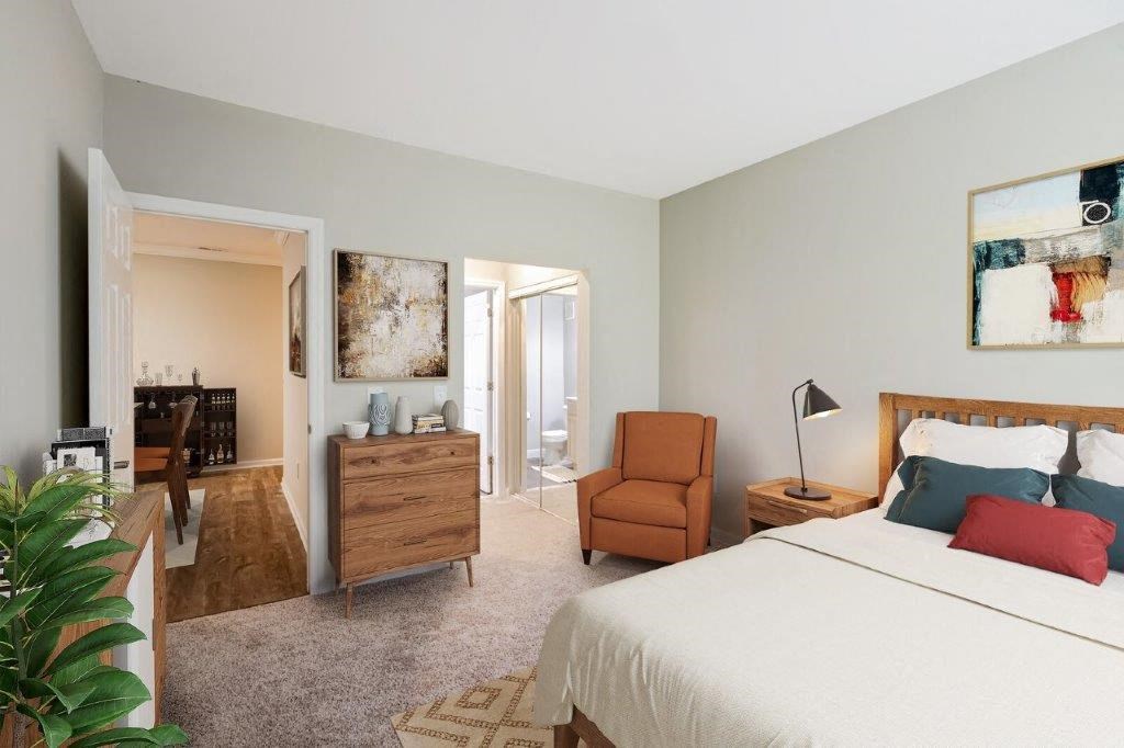 a bedroom with a bed and a chair and a living room