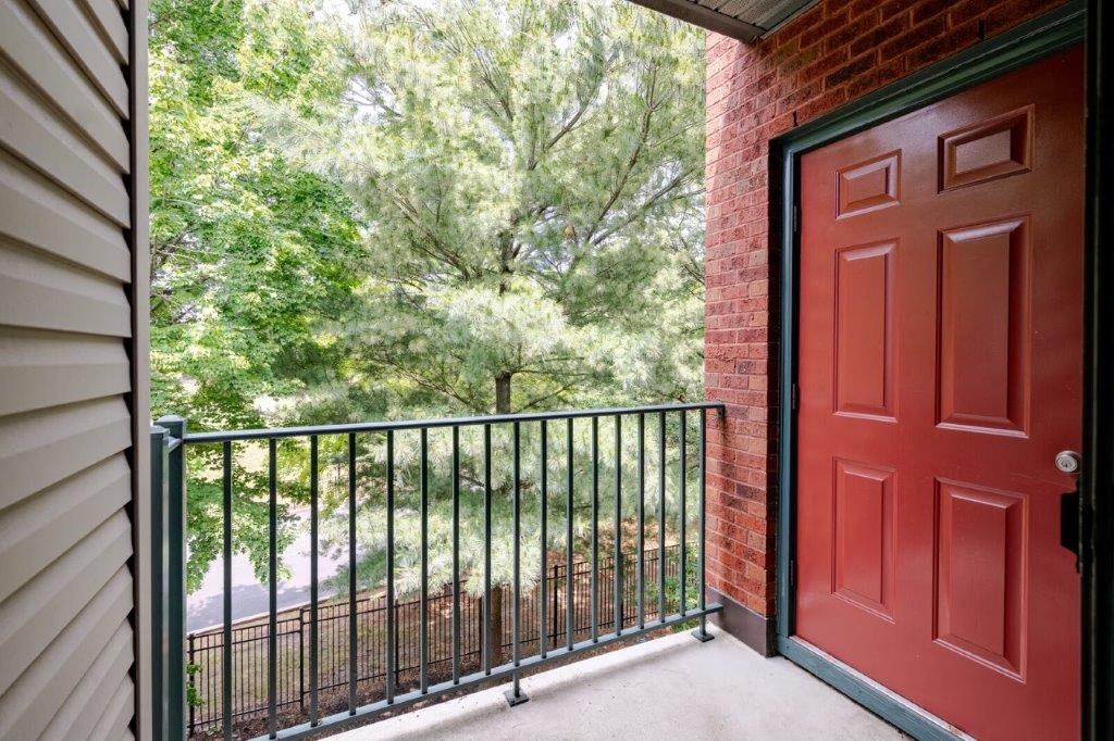 a balcony with a red door and a black railing