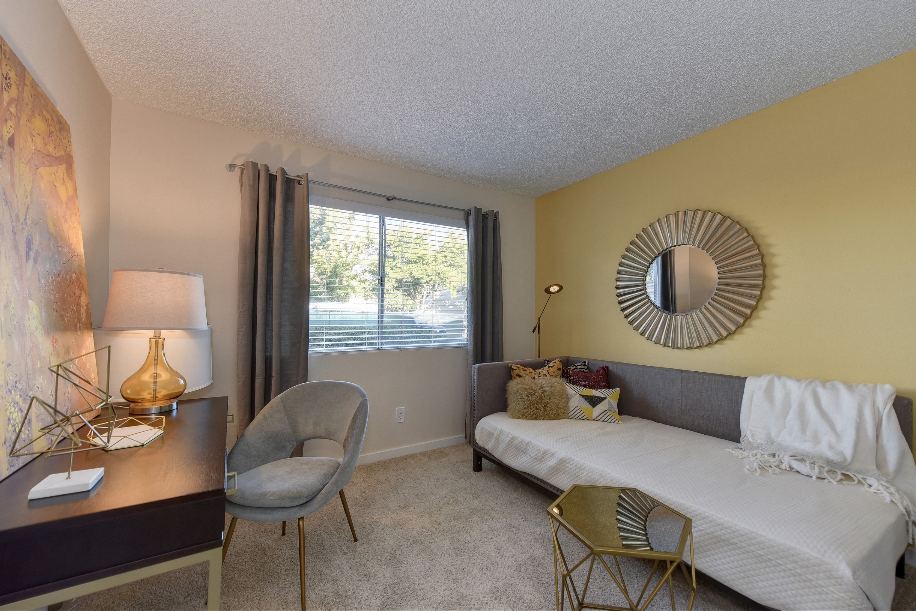 Bedroom with Large Window, White Dresser, and Gray Chair
