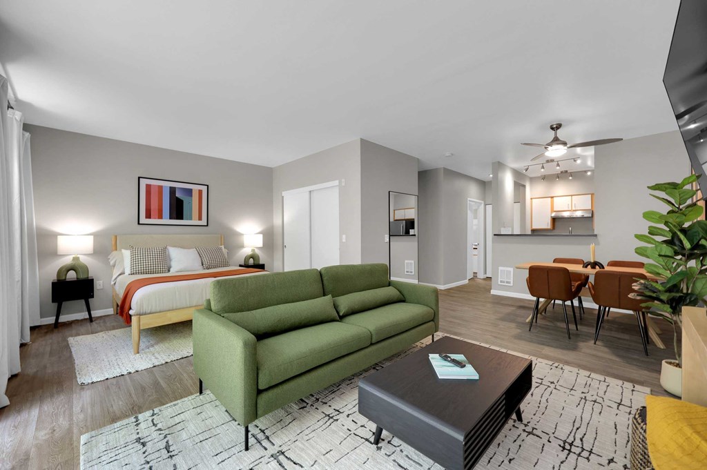 A living room with a green couch and a coffee table in the center.