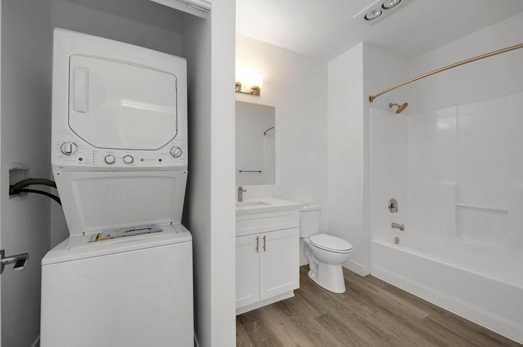 A white washing machine is in a small laundry room.