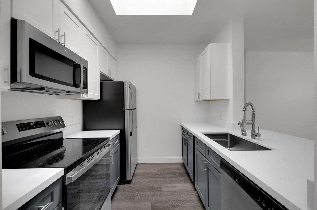 A modern kitchen with black and white appliances and cabinets.
