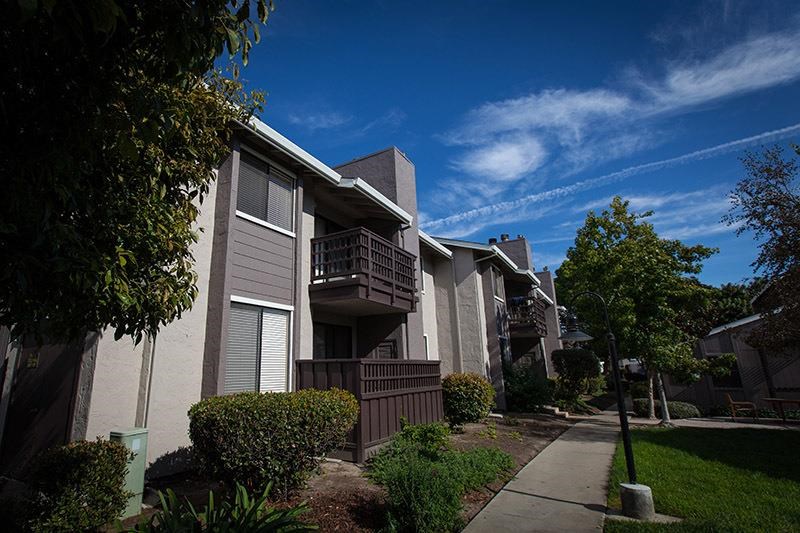 an apartment building with a sidewalk in front of it