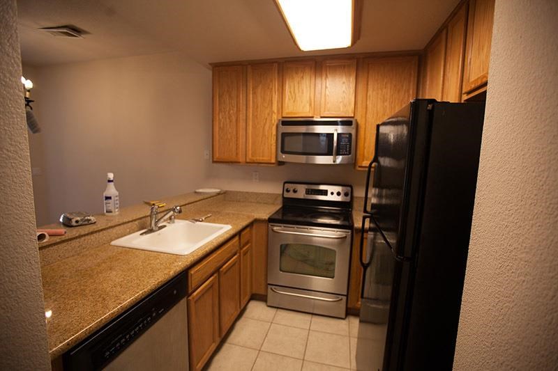a small kitchen with a sink stove and microwave