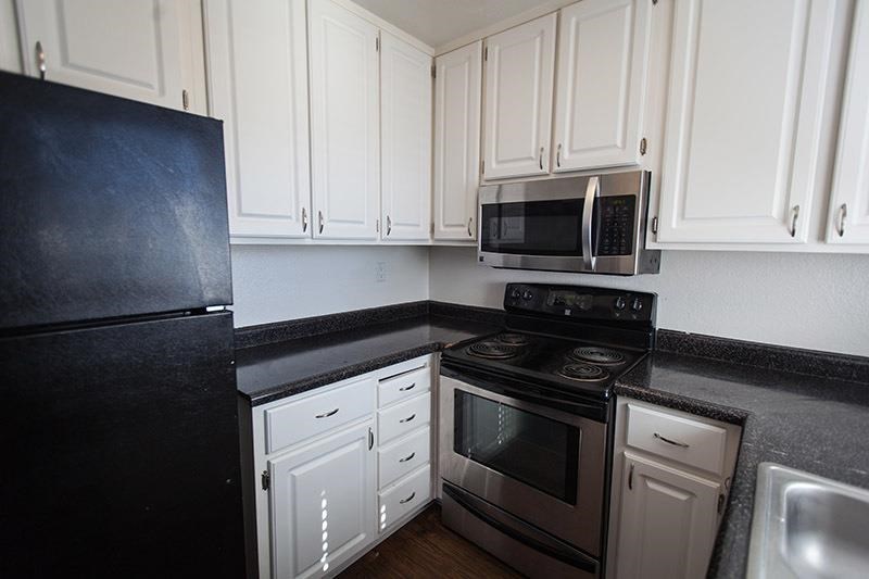 a kitchen with white cabinets and a stove and a microwave