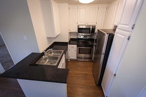 a kitchen with stainless steel appliances and black counter tops