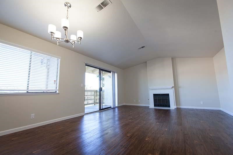 an empty living room with wood floors and a fireplace