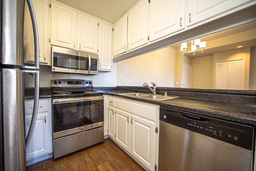 a kitchen with stainless steel appliances and white cabinets