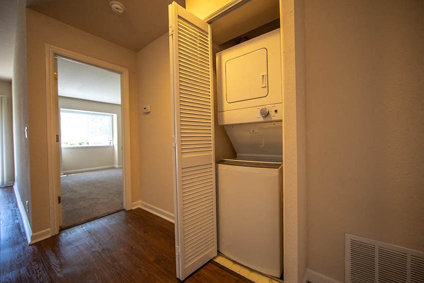 a small room with a white refrigerator and a washing machine