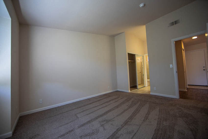 a empty living room with white walls and a carpet