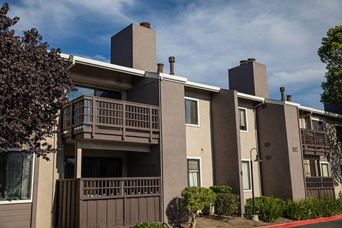 an apartment building with a balcony and a blue sky
