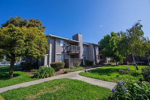 an apartment building with a sidewalk and trees