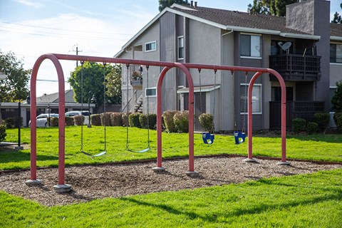 a swing set in a park in front of a house
