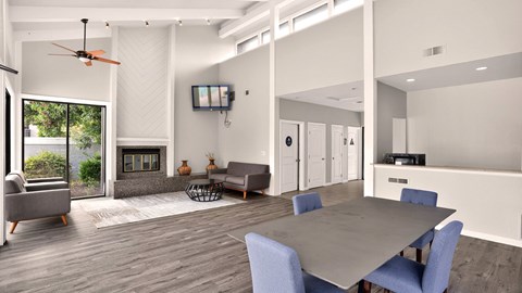 A modern living room with a grey table and blue chairs.