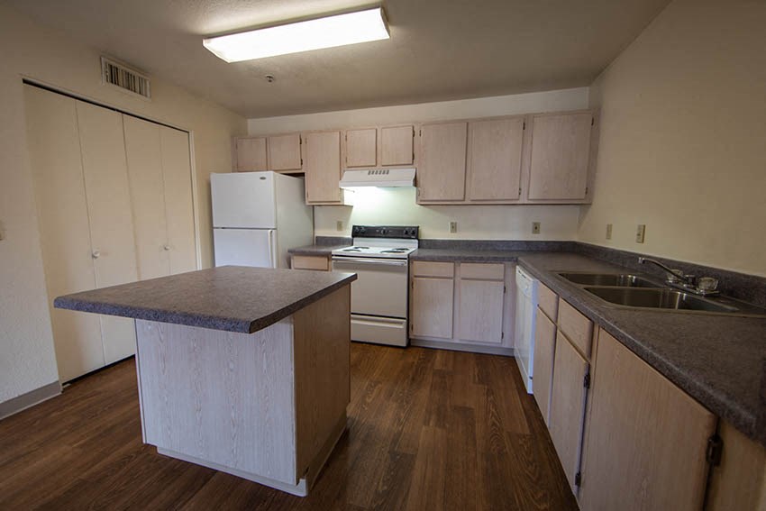 a kitchen with white appliances and counters and a sink