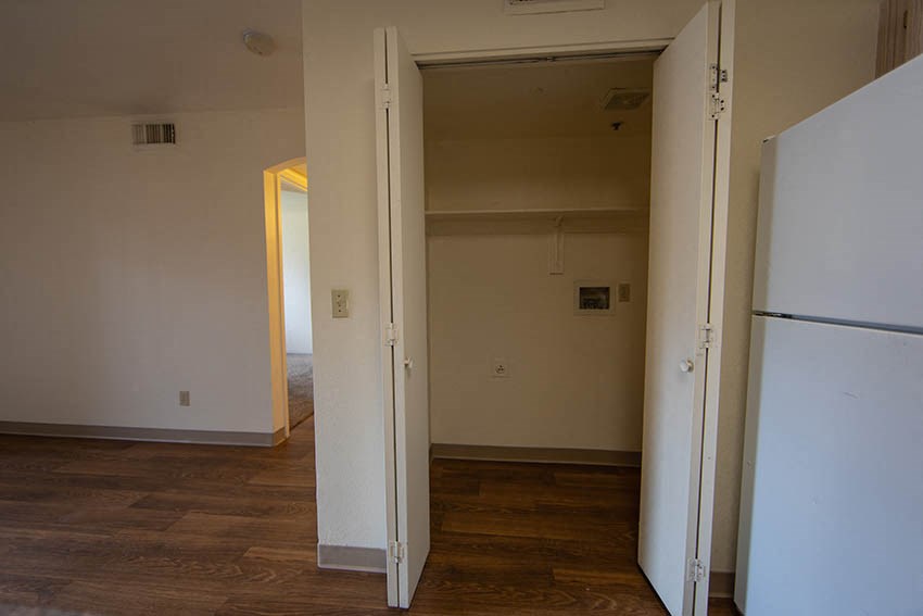an empty room with a refrigerator and a door