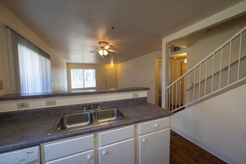 a kitchen with a sink and a ceiling fan
