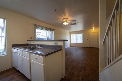 an empty kitchen and living room with a ceiling fan