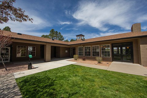 the front of a building with a lawn and a driveway