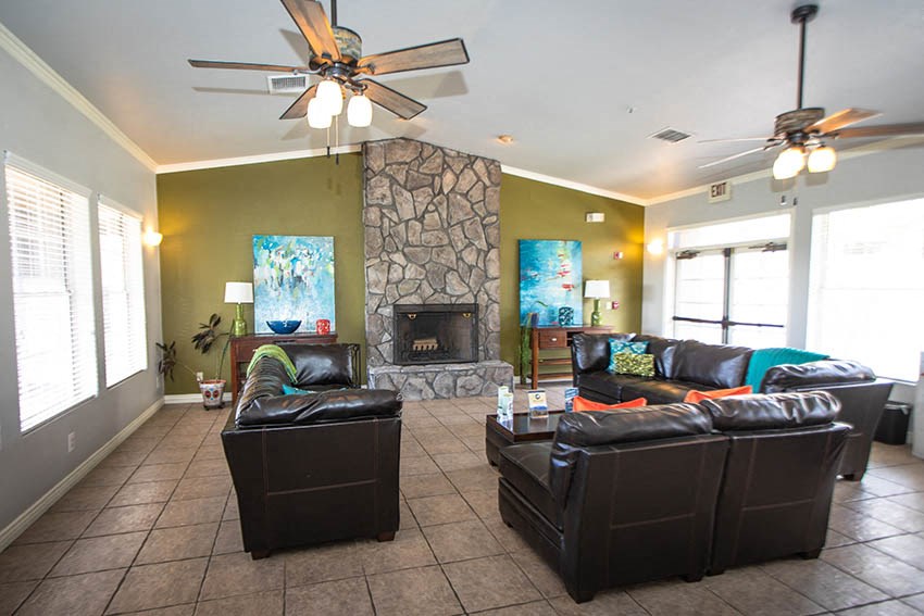 a living room with leather furniture and a stone fireplace