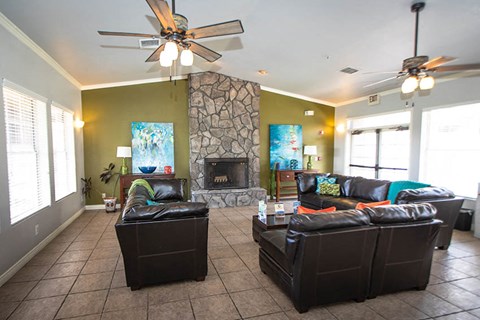 a living room with leather furniture and a stone fireplace