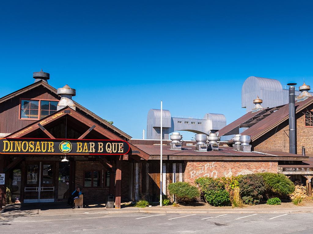 a restaurant with a dinosaur bar  cure on the side of a building