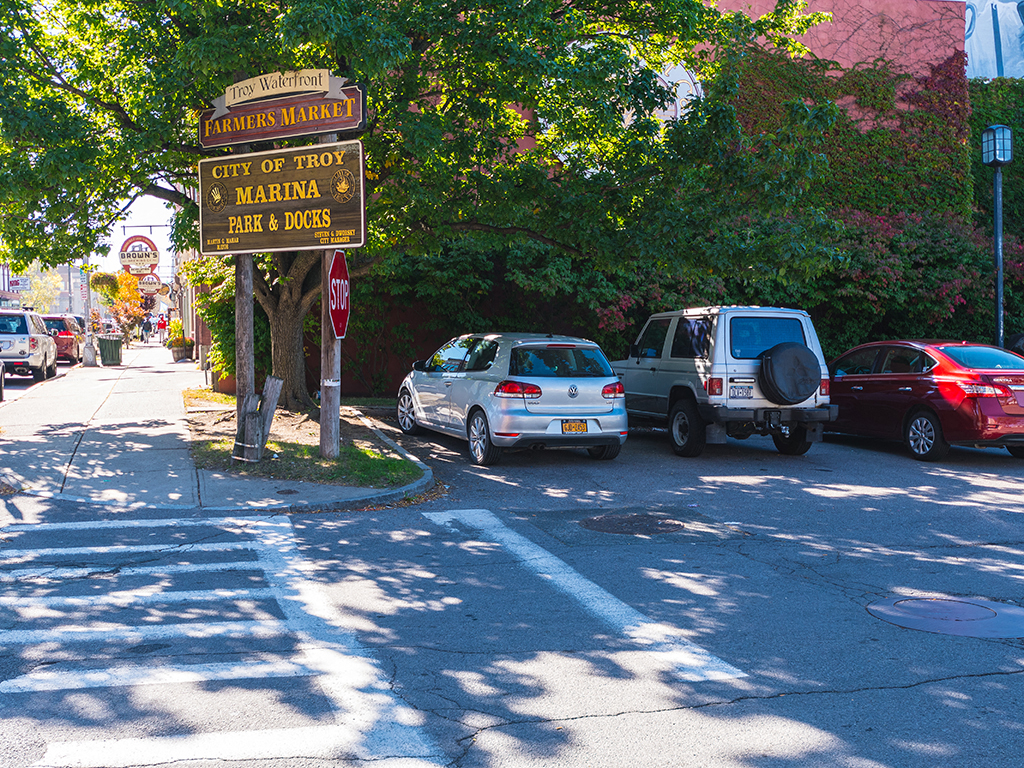 a city street with cars parked on the side of the road