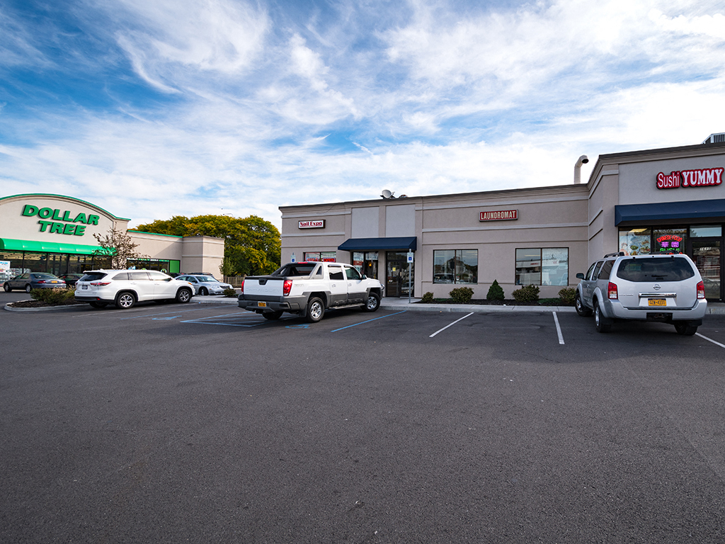 a parking lot in front of a shopping center with cars parked