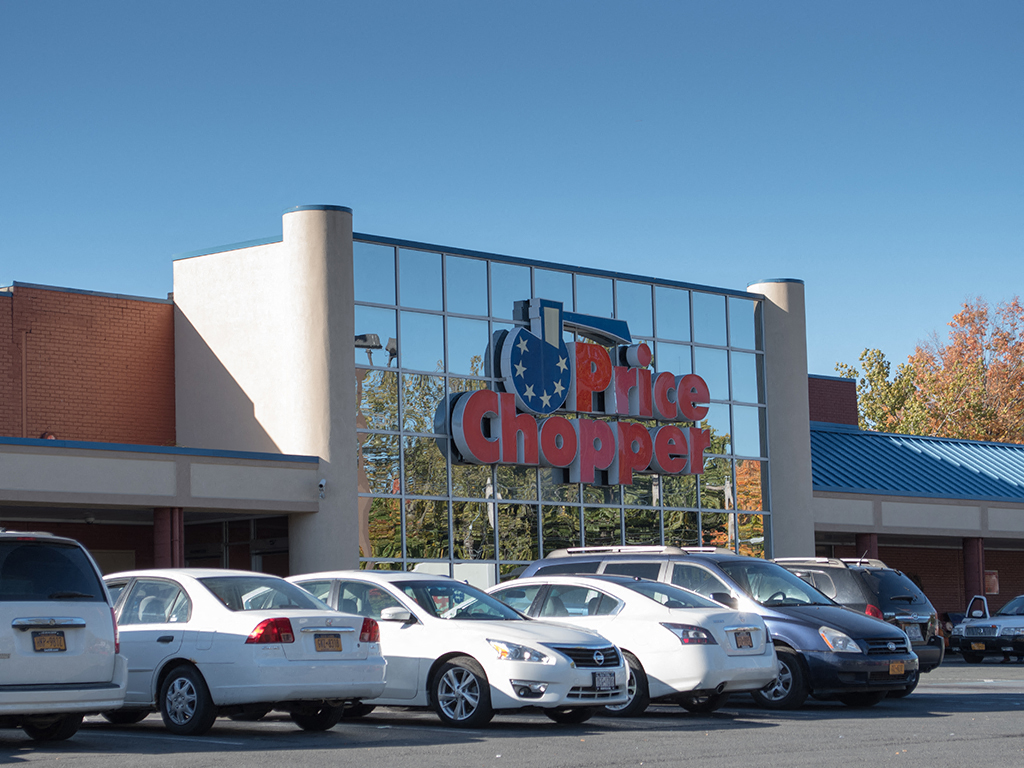 a parking lot full of cars in front of a large price chopper store