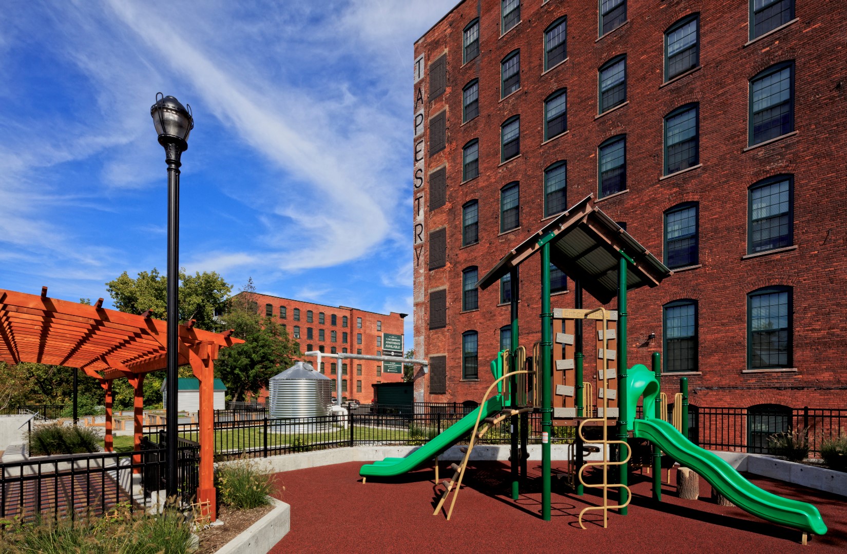 a playground with a large brick building and